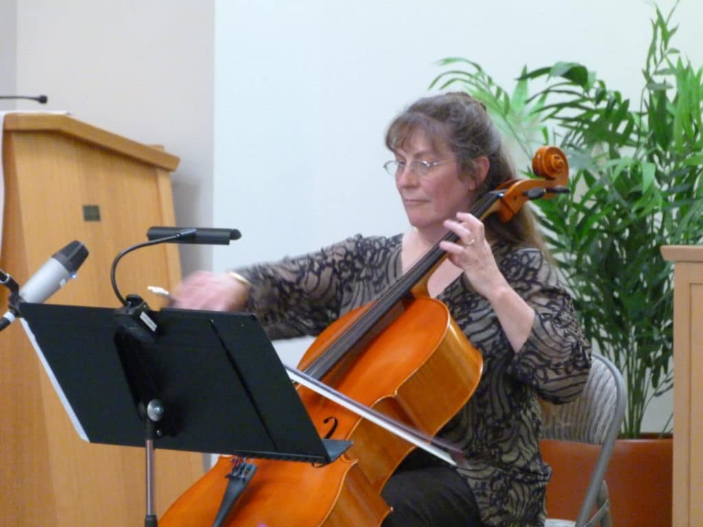 Marlene Moore playing her cello at an event.