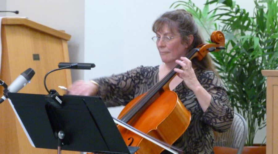 Marlene Moore playing her cello at an event.